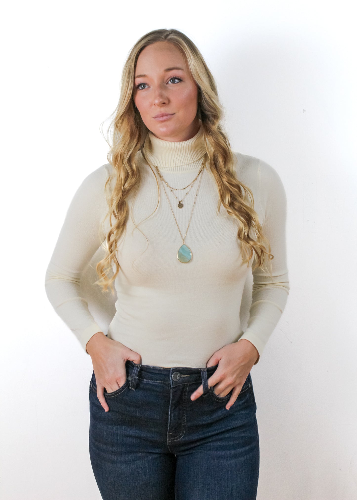 The Solid Color Turtleneck Sweater in Ivory color.