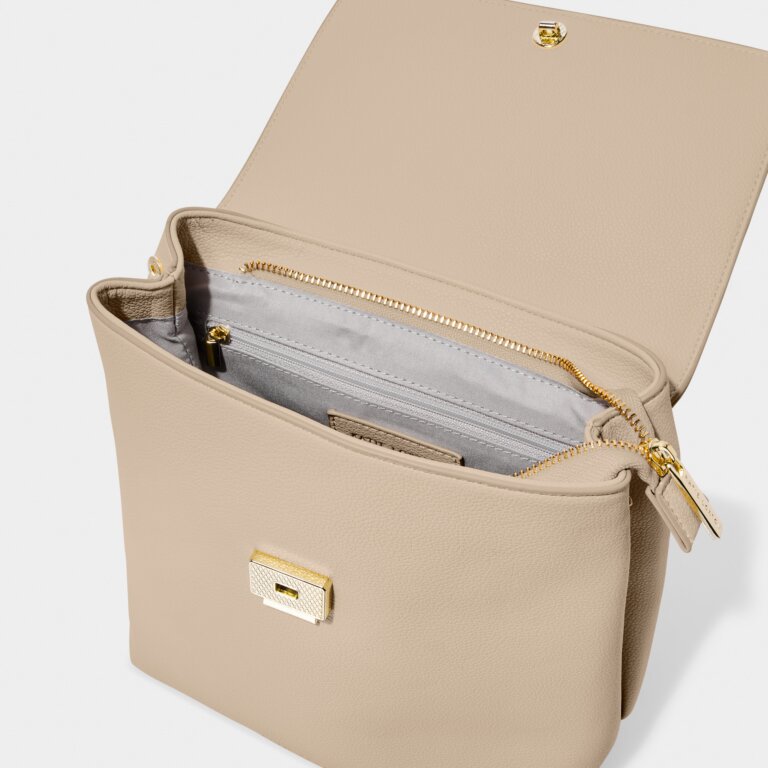 Showing the Demi Backpack the inside. One internal compartment with a top zipper closure and a back wall zipper pocket.