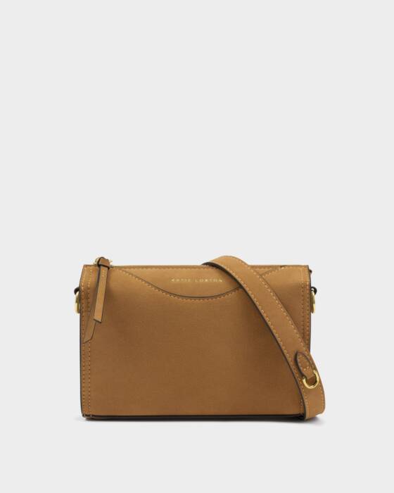 Tan leather handbag with a strap on a light gray background