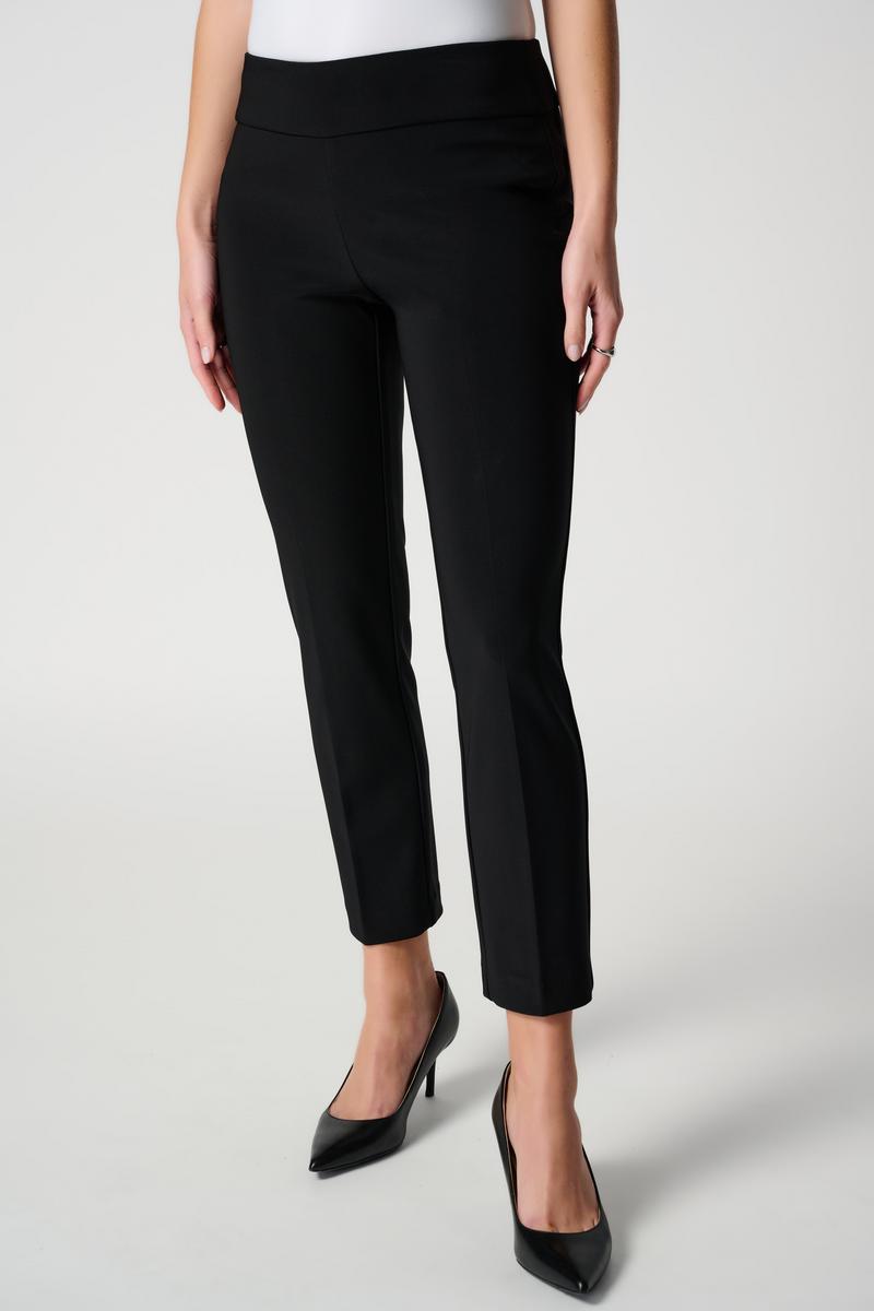 Person wearing black pants and black shoes on a white background