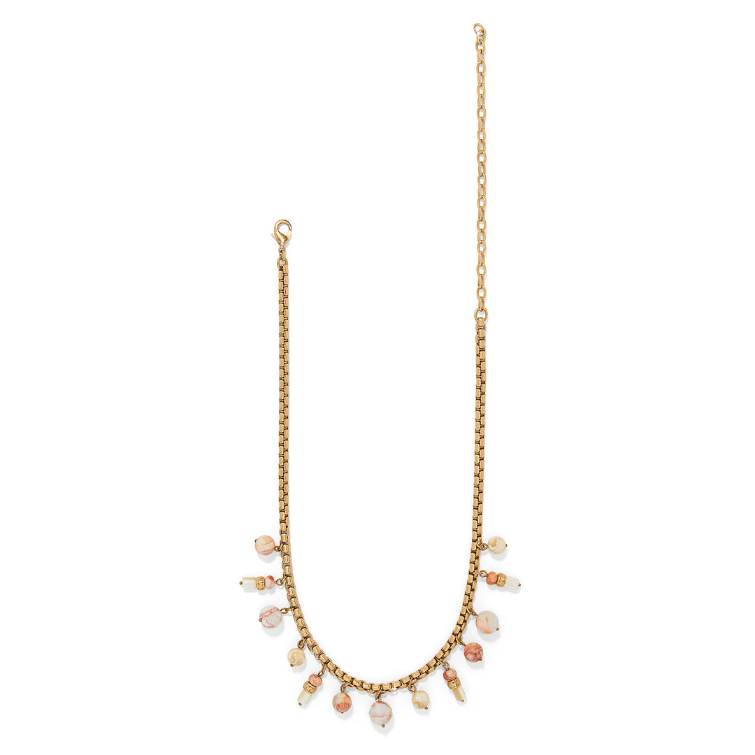 Gold necklace with small pearls on a white background, showing the entire necklace.