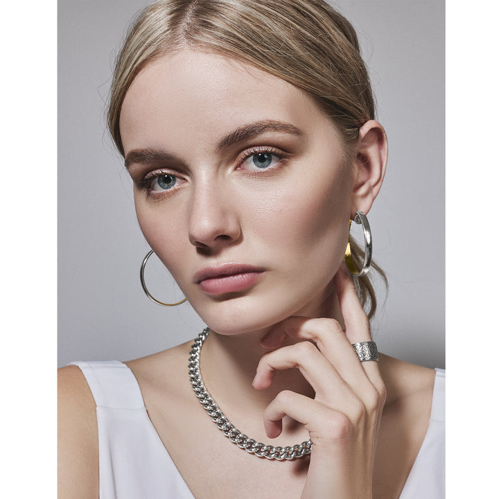 A woman wearing the Brighton Ferrara Roma Curb Chain Necklace with some silver hoop earrings