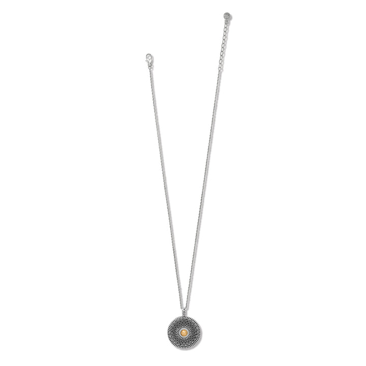Silver necklace with a circular pendant on a white background