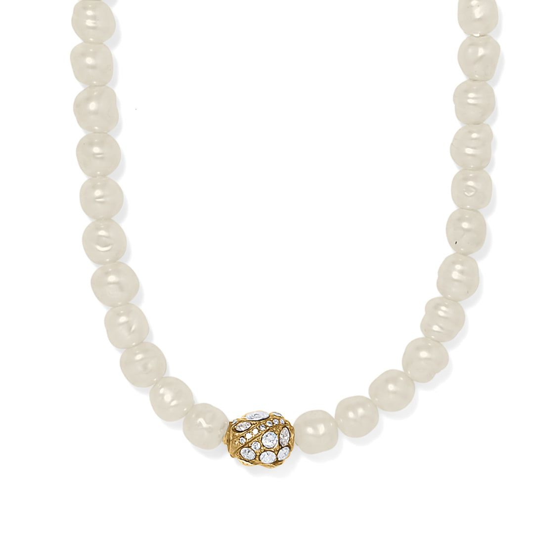 Pearl necklace with a gold and crystal clasp on a white background
