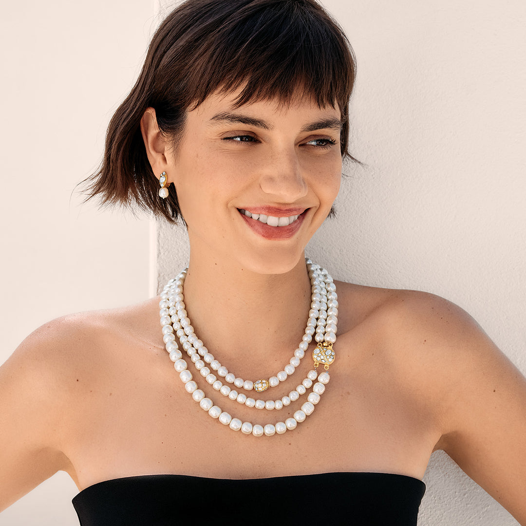 Woman wearing a pearl necklace with a plain background