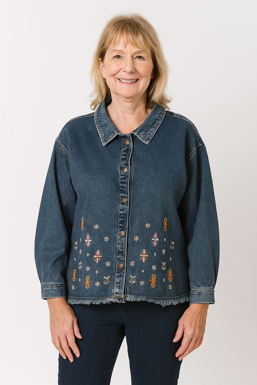 Woman wearing a blue denim jacket with floral embroidery on a white background