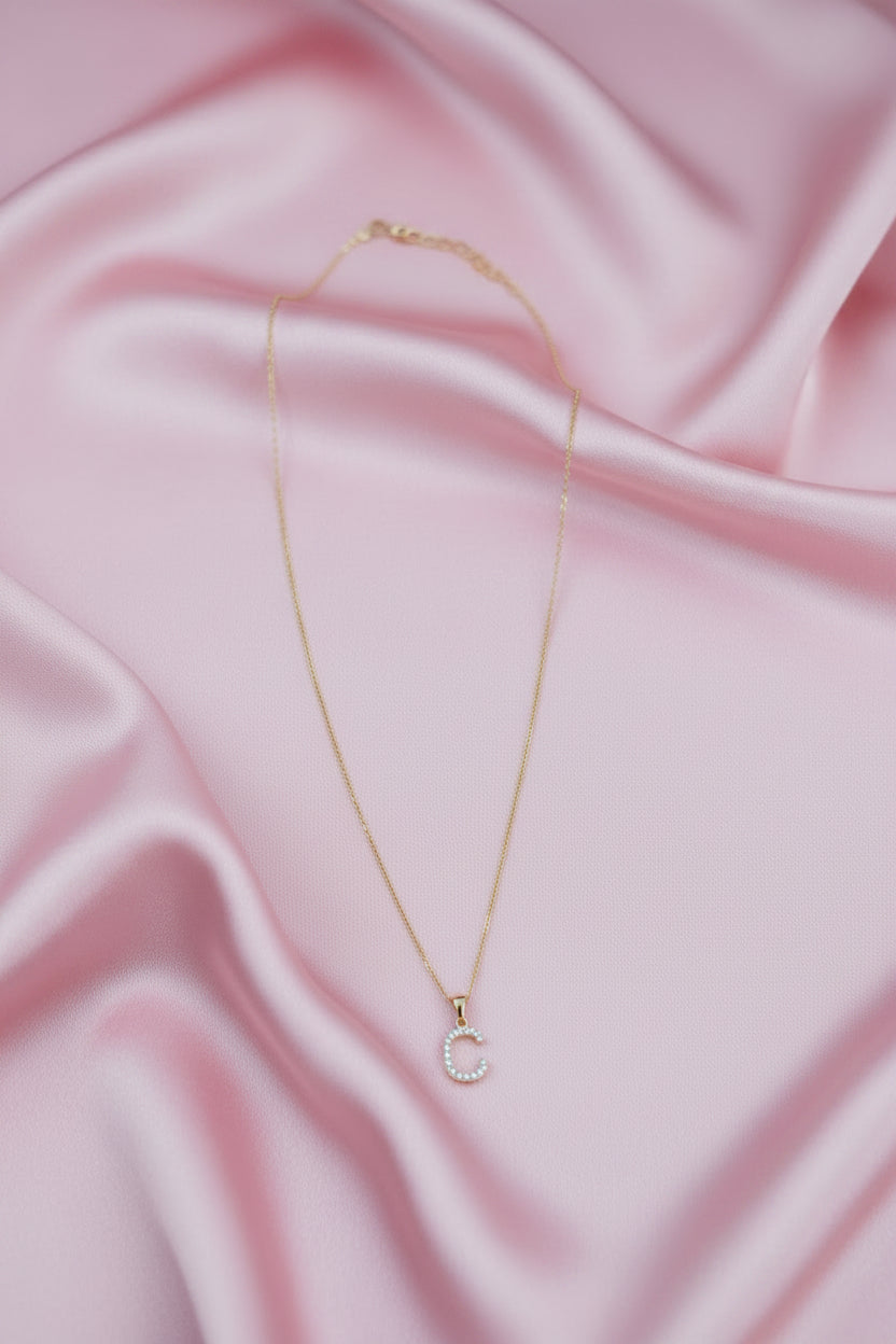 A delicate gold chain necklace with a small letter &