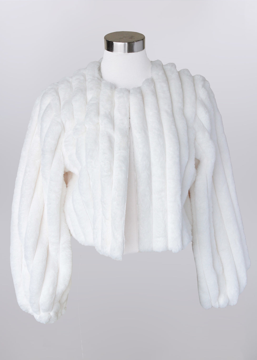 White fur shrug on a mannequin against a plain background