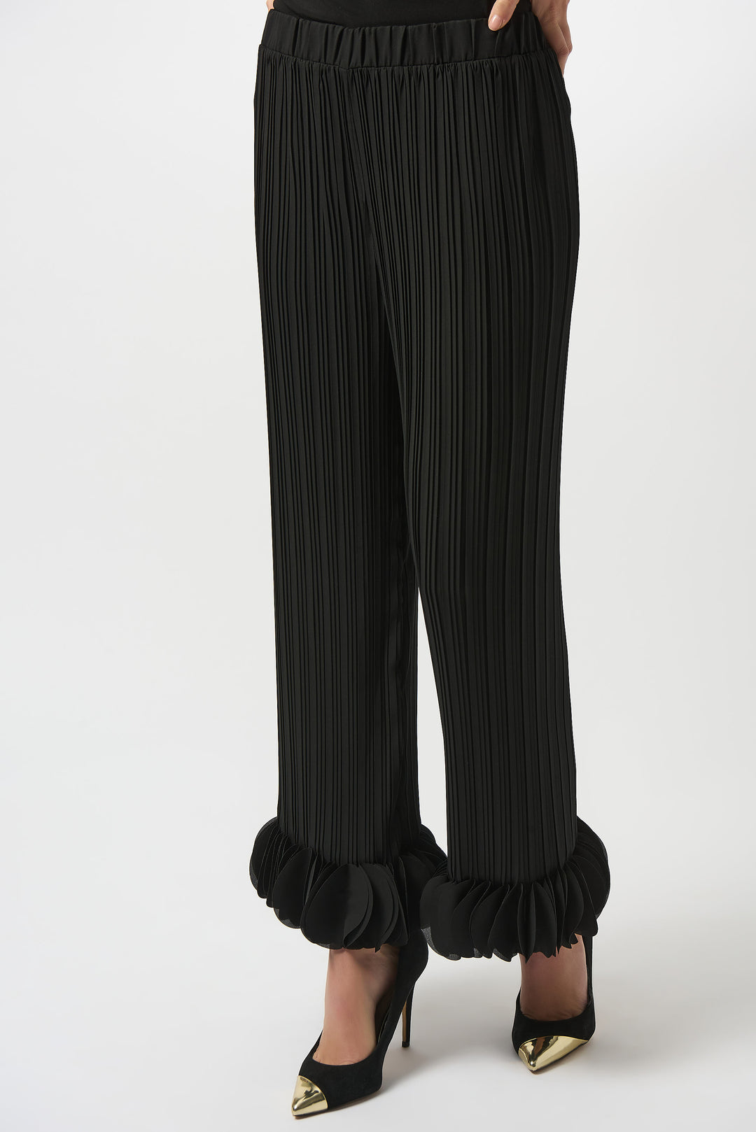 Black pleated pants with ruffled cuffs on a white background