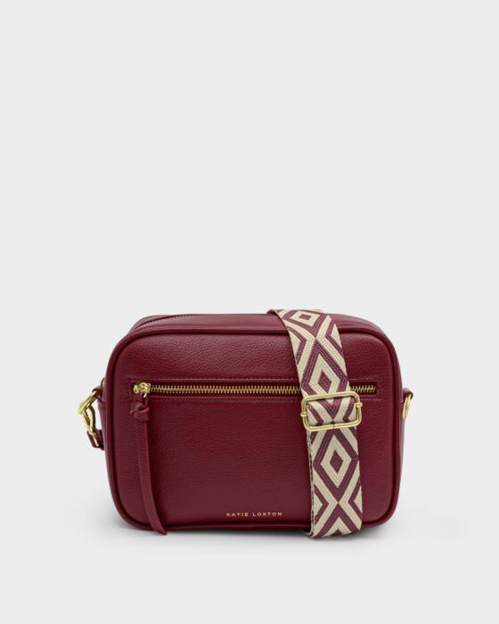 Red handbag with a patterned strap on a light gray background