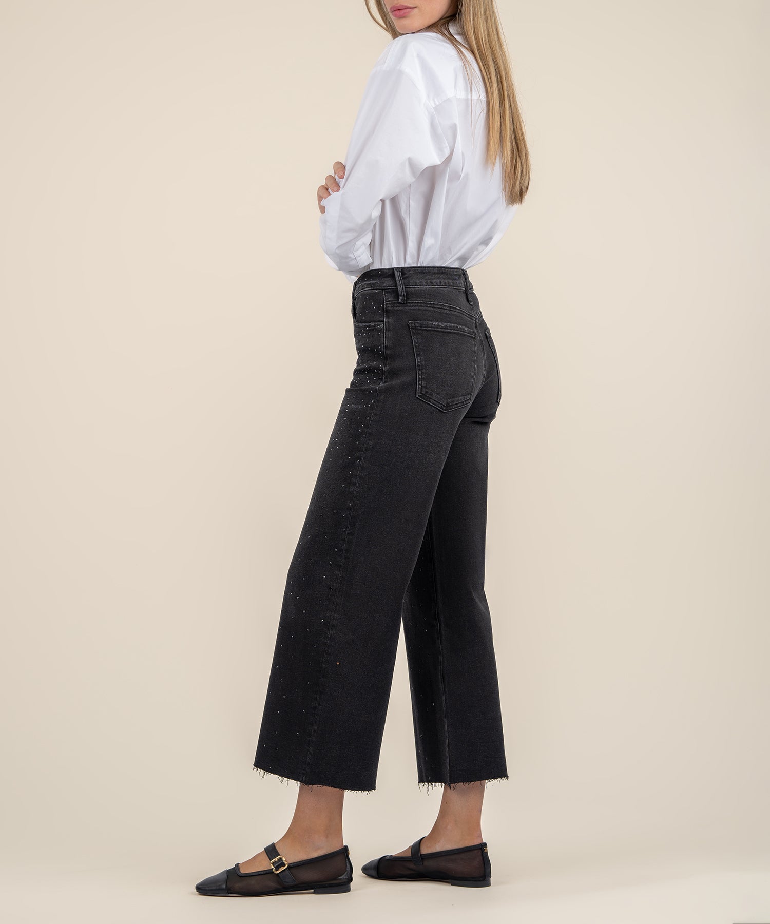 Illuminated Wide Leg Raw Hem Denim Pants in color black. A side view.