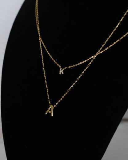 Photo showing the Mini Pave Initial Necklace - Letter K with the 18K Gold Initial Block Necklace - letter A.
