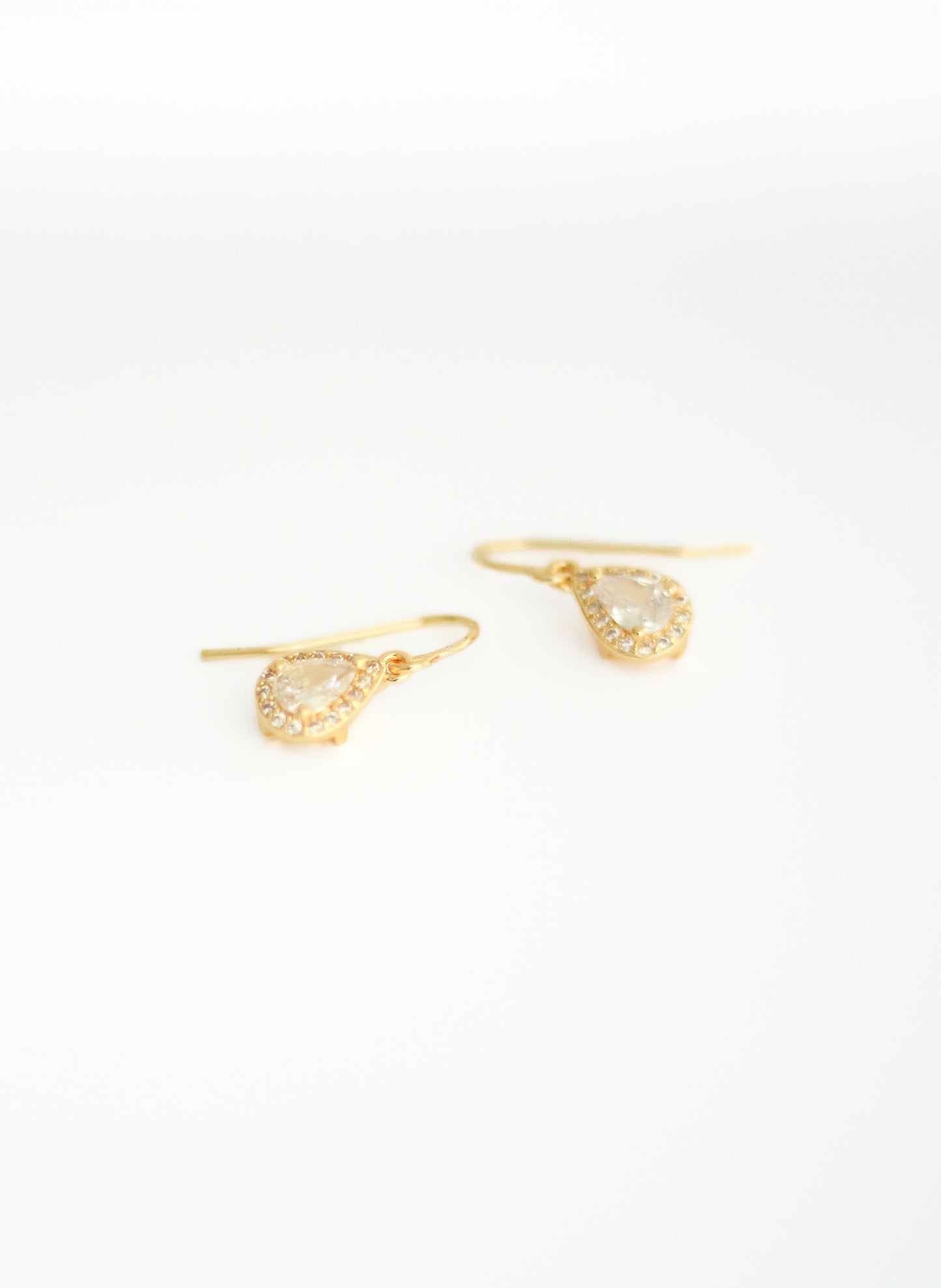 Small Teardrop Halo French Wire Earrings showing laying down. At Kadou Boutique. Free Shipping.