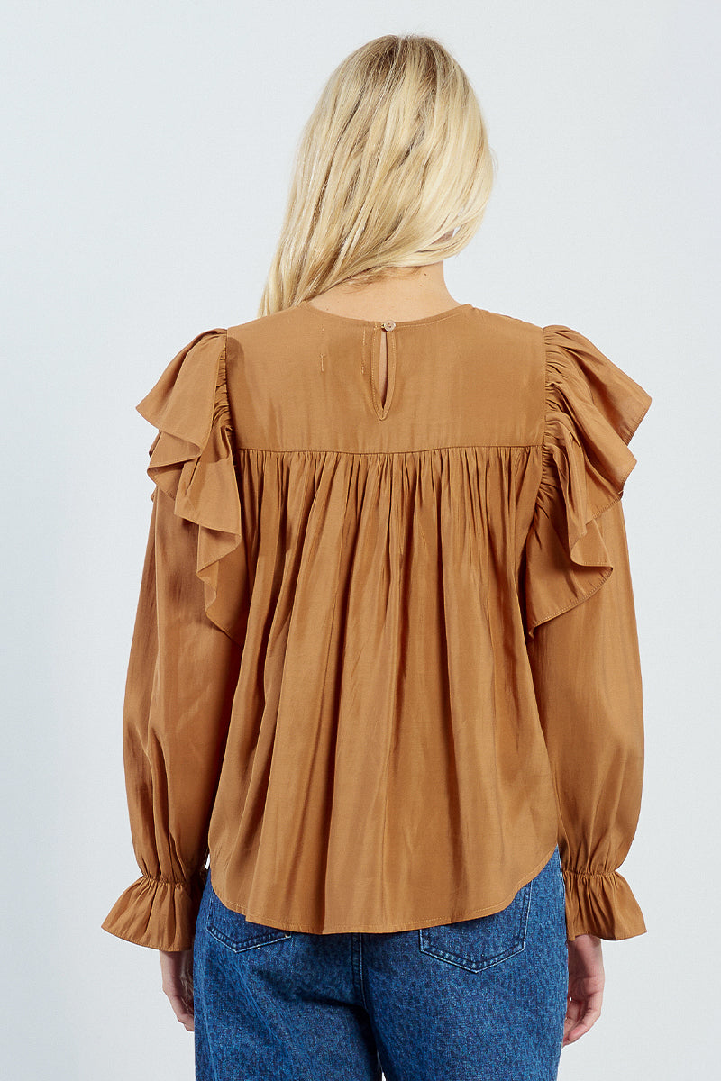 Brown blouse with ruffled sleeves worn by a person on a white background. A back view
