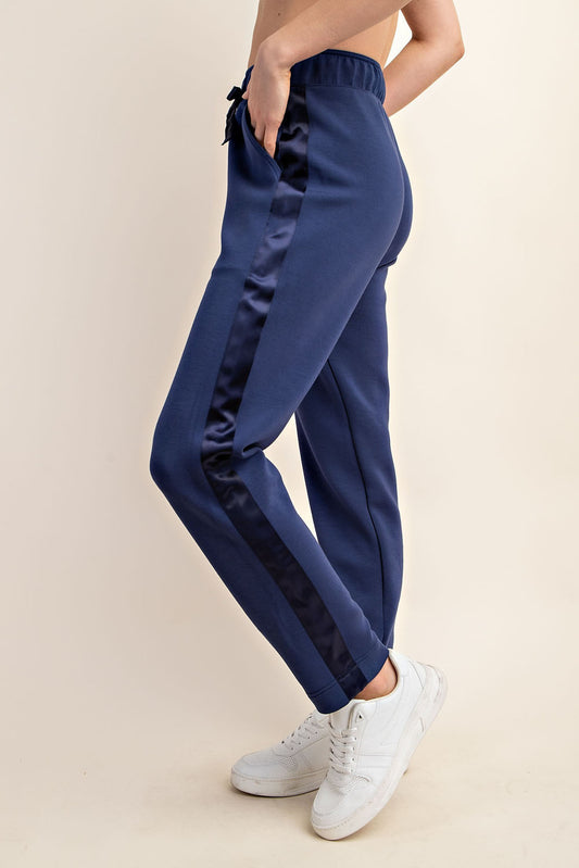 A model showing the Modal Jogger with Satin Side Detail in Smokey Navy color. Side view. Available at Kadou Boutique.
