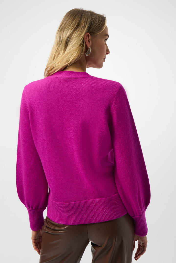 Person wearing a bright pink sweater on a white background