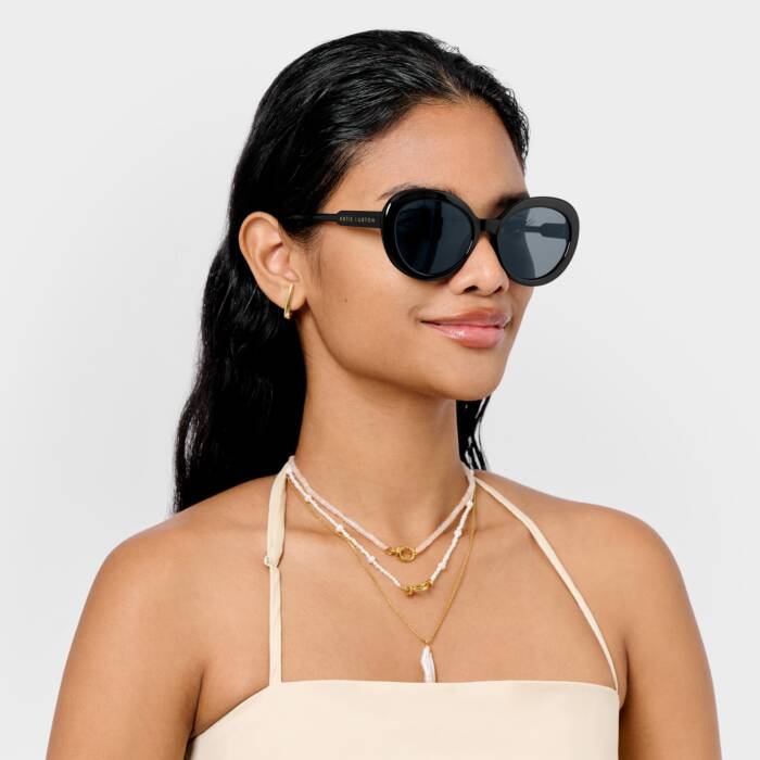 Woman wearing black sunglasses with a plain background