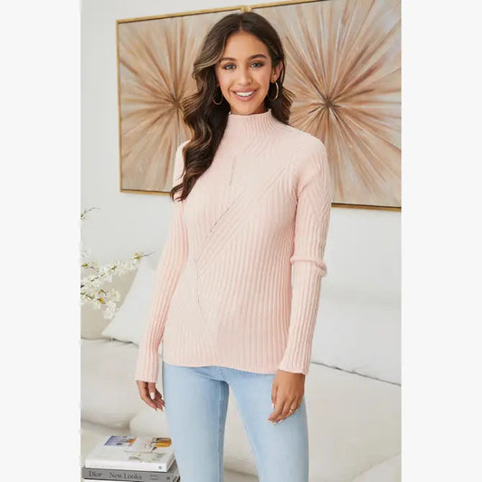 A model is wearing the Rib Mock Neck Sweater in blush color. Available at Kadou Boutique.