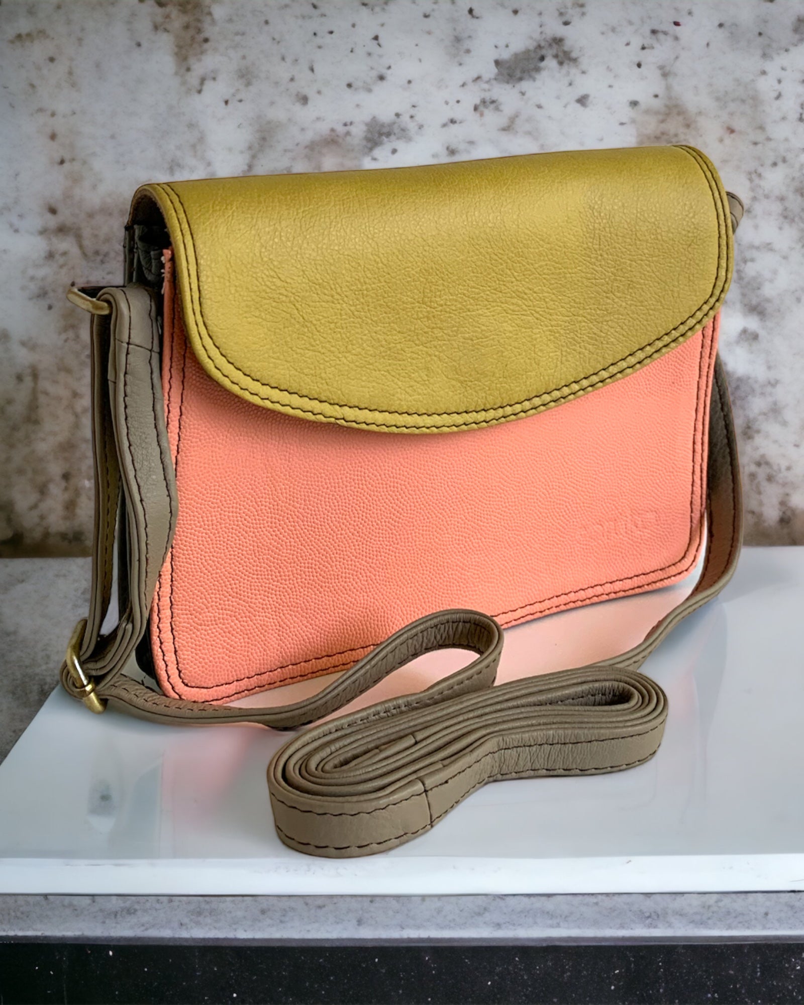 Soruka Beth Multicolored Leather Crossbody Satchel in Peach-colored front and Mustard-colored flap. The crossbody leather strap is adjustable and in grey color. Available at KADOU Boutique.