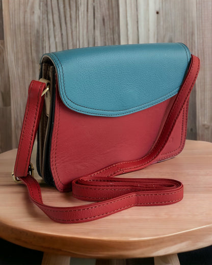 Soruka Beth Multicolored Leather Crossbody Satchel In Red front and Blue flap. The Crossbody leather strap is adjustable and in Red color. Available at KADOU Boutique.