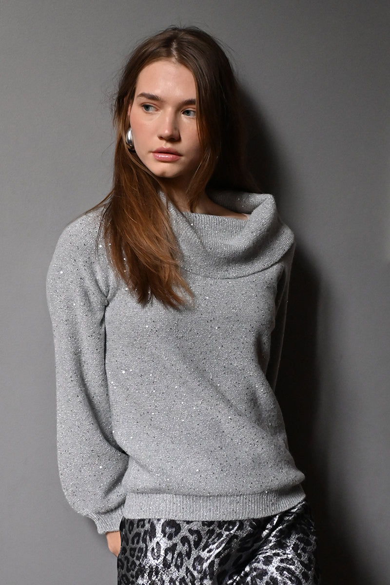 Woman wearing a gray sweater against a gray background