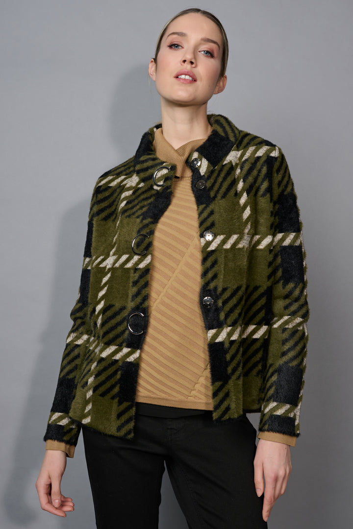 Woman wearing a plaid jacket over a brown shirt on a gray background
