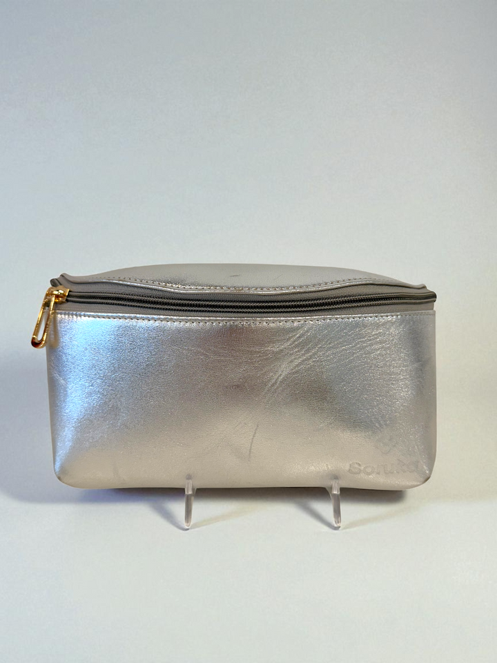 Silver metallic pouch with gold zipper on a white background