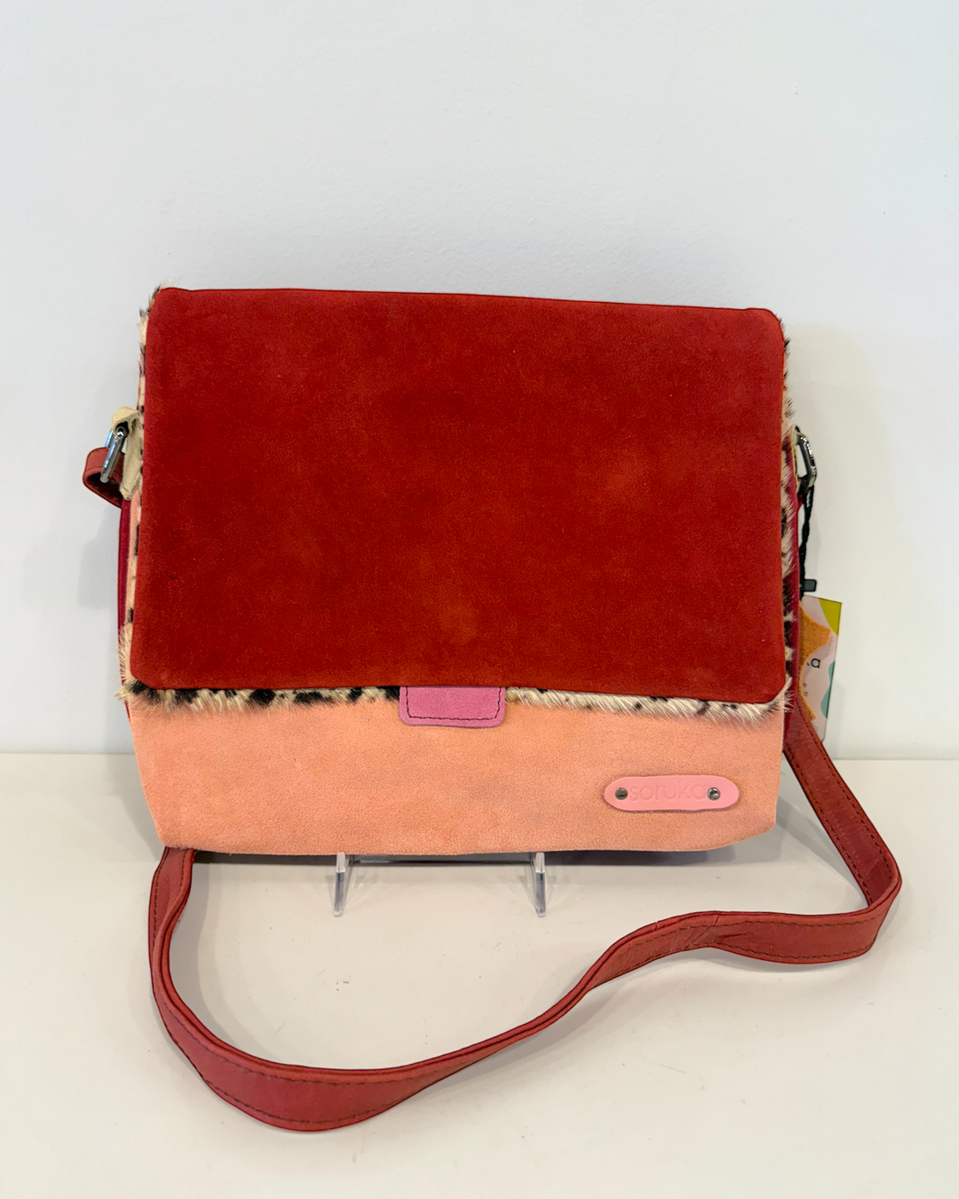 Red and pink crossbody bag on a white background
