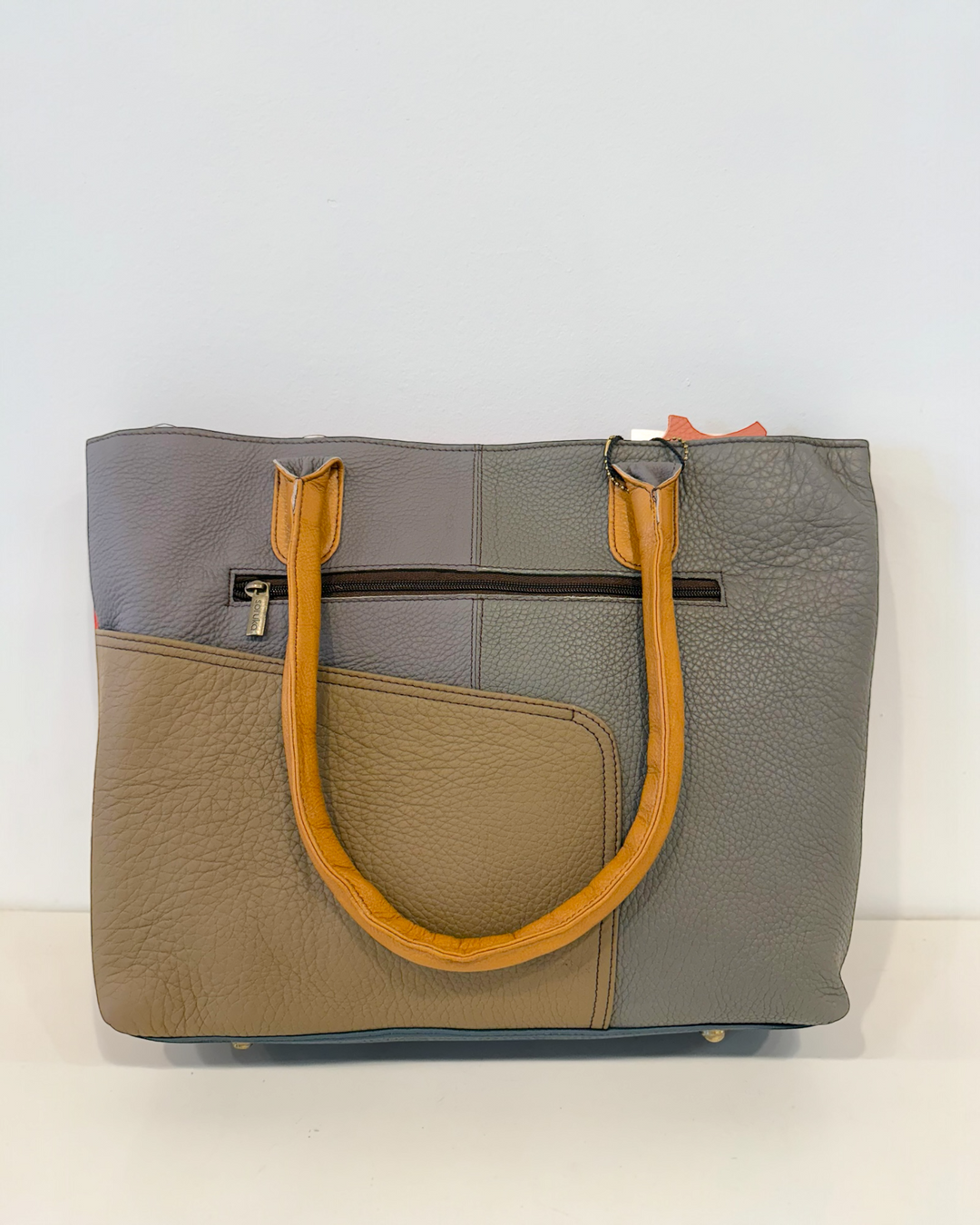 The back view, showing Two-toned handbag with gray and beige sections on a white background