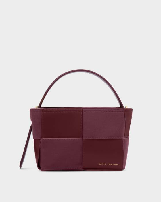 Burgundy handbag with patchwork design on a light gray background