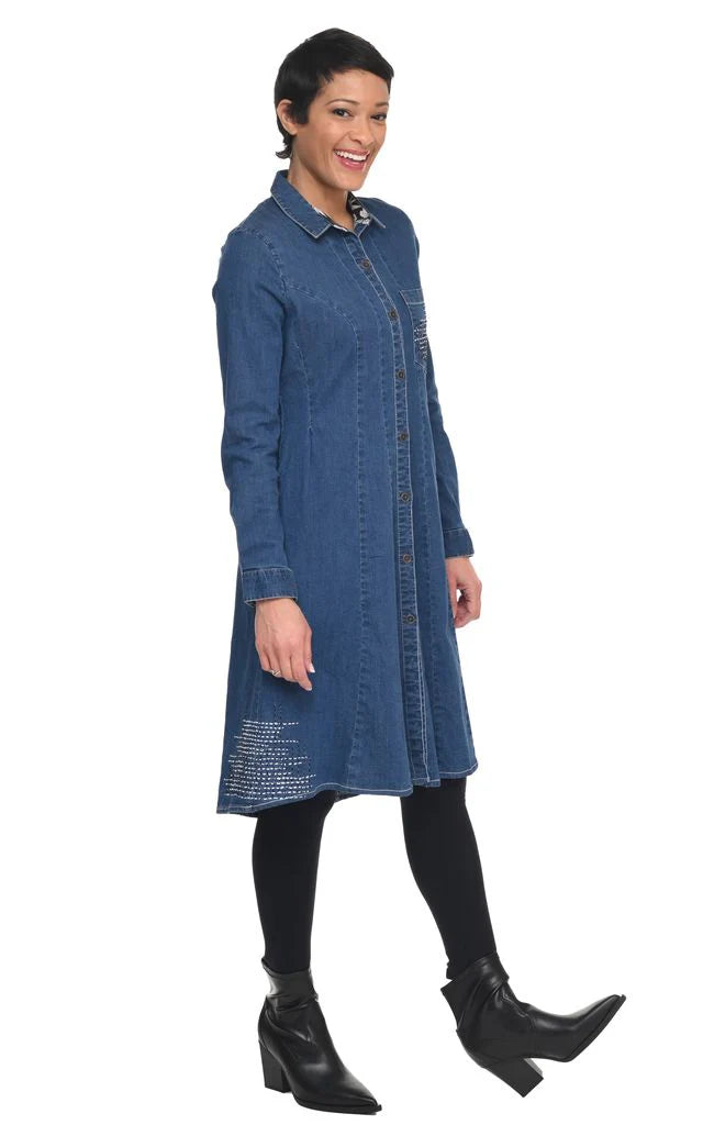 Woman wearing a blue denim dress with a white background