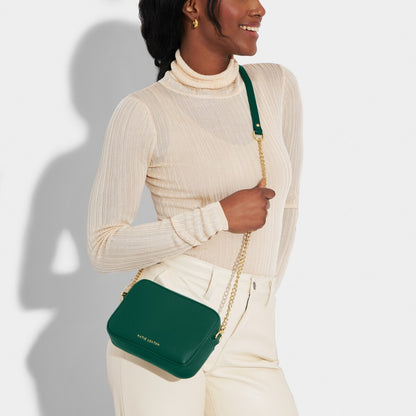 Showing a model holding the Millie Mini Crossbody in Emerald Green.
