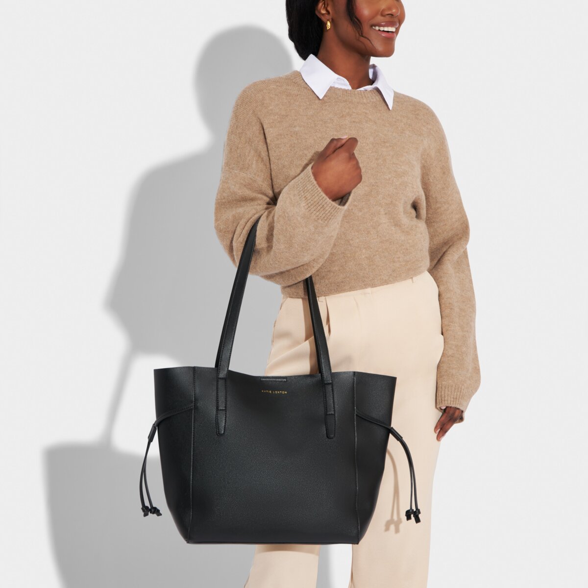 A model is holding the Ashley Tote Bag in Black.