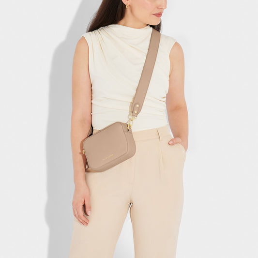 A model is wearing the Zana Mini Crossbody Bag in Soft Tan. You can order it online at kadou.shop.