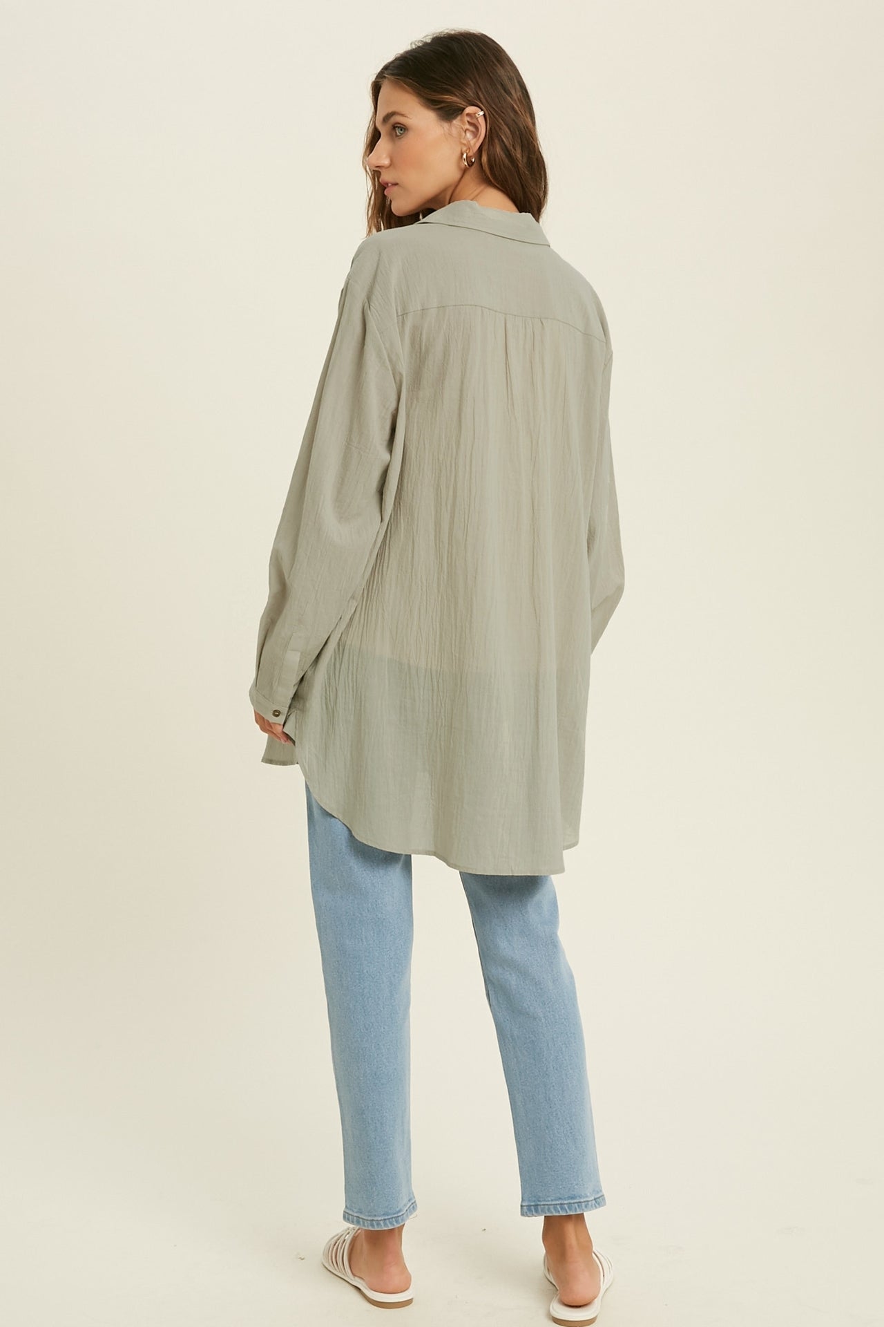 Showing a model wearing the Button Down Tunic Top in sage color. A back view.