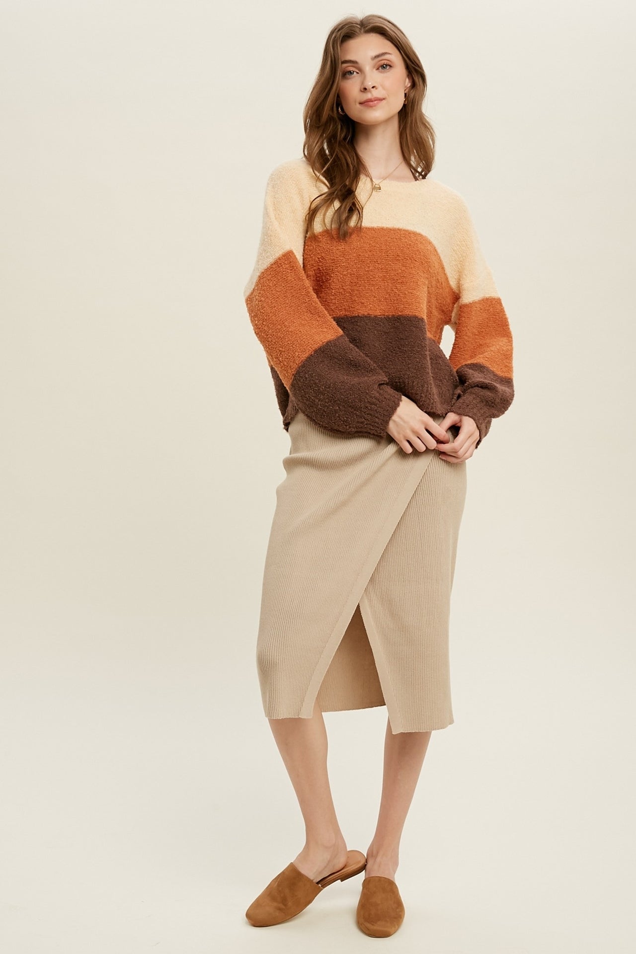 The model is wearing the Colorblock Balloon Sleeve Sweater over a beige skirt.