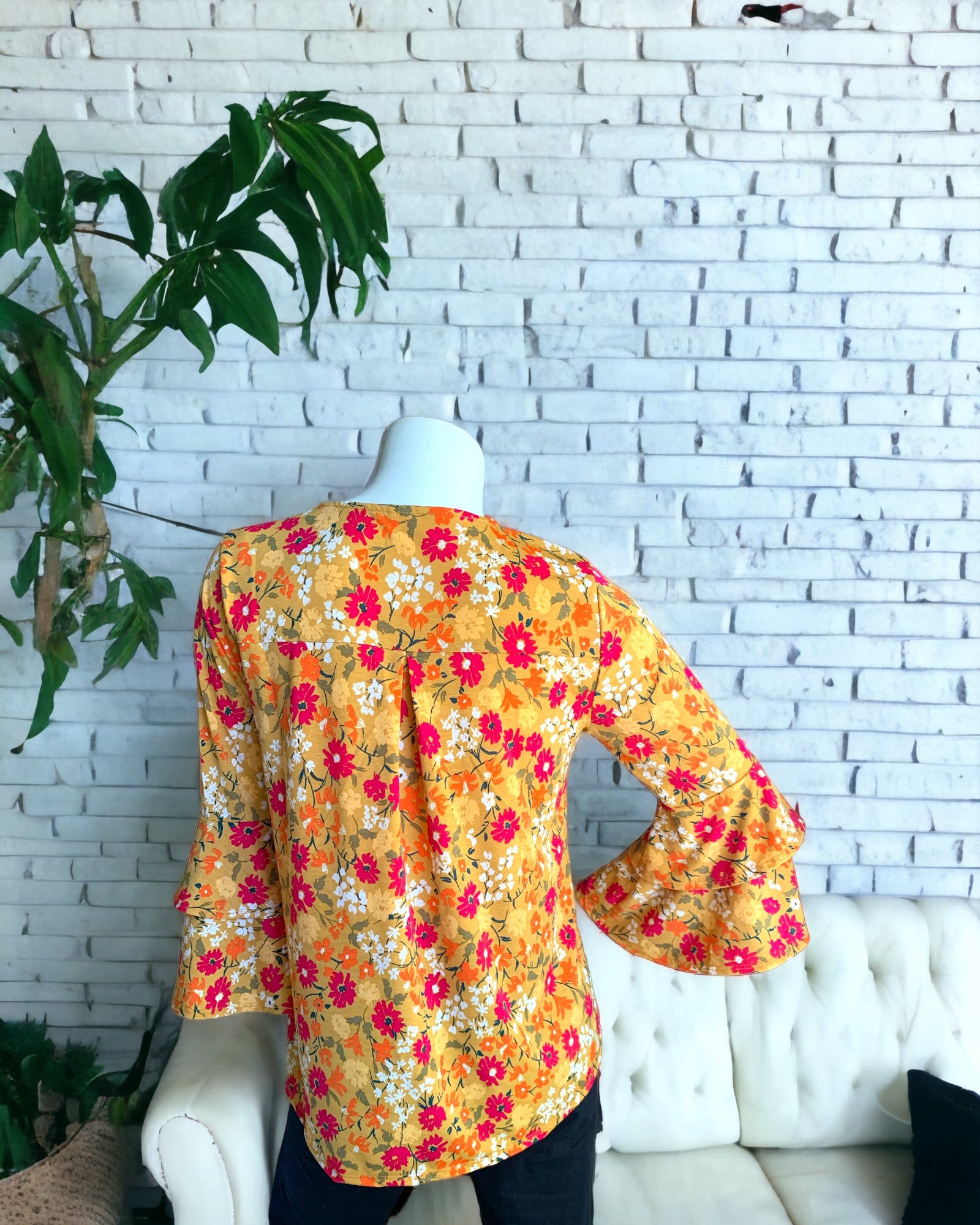 Tiered Ruffle Long Sleeve Marigold Floral Top worn with black leggings. Back view.