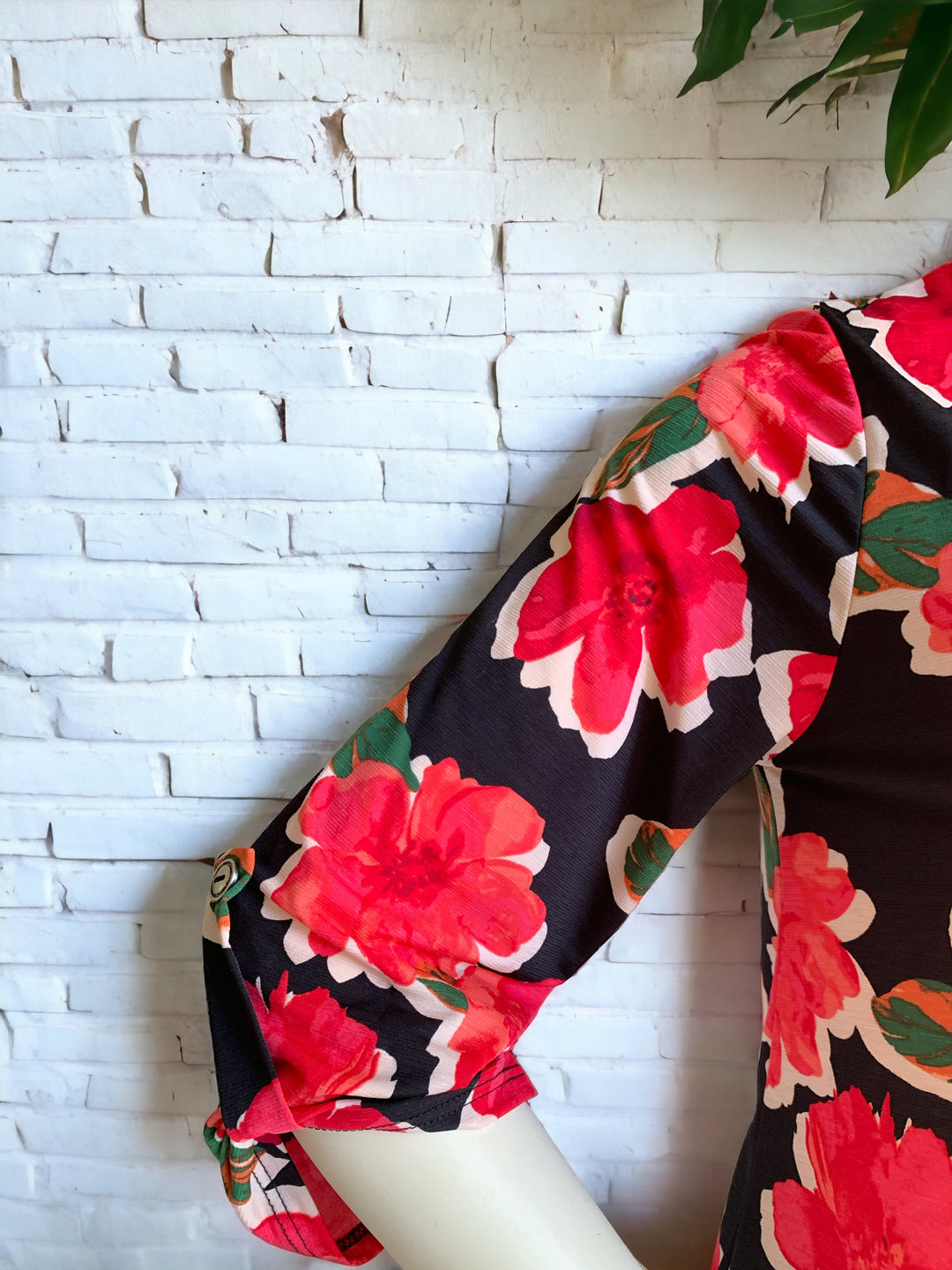 The photo is showing the 3/4 sleeve of the Red Peony Top with the button detail at the end of the sleeve.