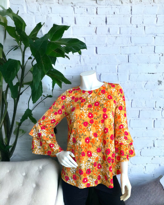 Tiered Ruffle Long Sleeve Marigold Floral Top worn with black leggings. Available at Kadou Boutique.