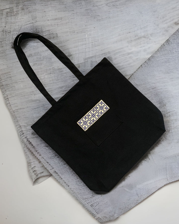 Tatreez Fabric Tote Bag in Black color and Blue embroidery on the outside pocket.